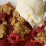 Delicious homemade Raspberry Crisp served in a dish, featuring tart berries and crunchy topping.