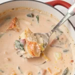 Seasonal summer vegetable stew served with buttered bread in a one-pot dish