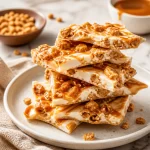 High-protein salted caramel pebble bark on a wooden table