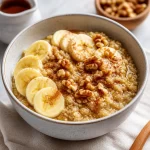 Bowl of maple cinnamon breakfast quinoa topped with fresh fruit and nuts