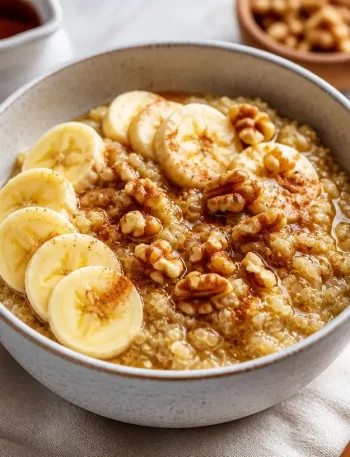 Bowl of maple cinnamon breakfast quinoa topped with fresh fruit and nuts