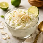 Protein Coconut Lime Silk in a glass, garnished with lime and coconut.