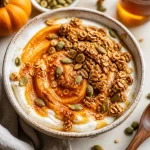 Delicious Pumpkin Yogurt Breakfast Bowl topped with nuts and seeds